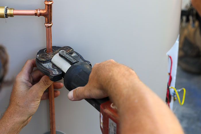 Plumber fitting copper pipes on a hot water system in Maroochydore